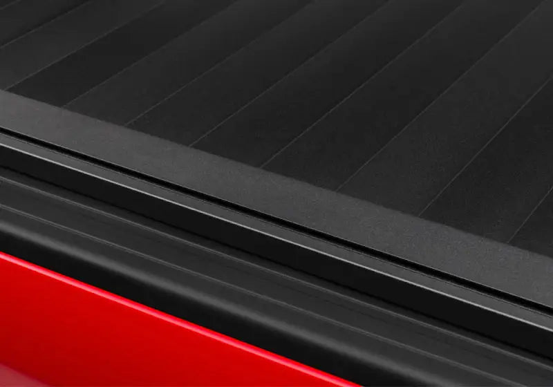 Black truck bed cover for Tacoma 5ft Double Cab RetraxPRO XR in action