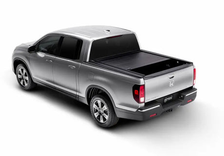 Silver pickup truck with tonneau cover featuring Ridgeline RetraxPRO and sealed ball-bearing rollers
