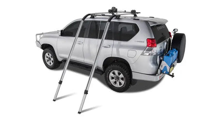 Silver SUV with roof rack and spare tire using Rhinorack Nautic Kayak Lifter for kayak hauling