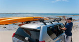Silver SUV with kayaks on roof rack using Rhino-Rack Nautic Kayak Lifter for easy transport