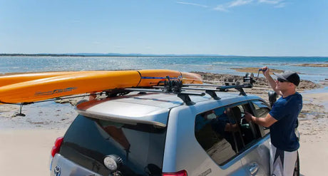 Silver SUV with kayaks on roof rack using Rhino-Rack Nautic Kayak Lifter for easy transport