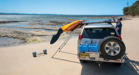 Silver SUV with Rhino-Rack Nautic Kayak Lifter carrying a kayak on roof rails