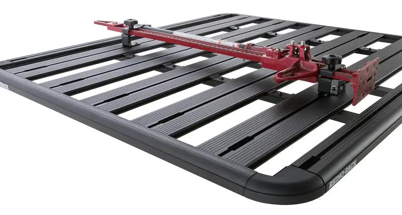 Rhino-Rack Pioneer High Lifting Jack Holder Bracket Set (Top Mount) securely attached to a black Rhino-Rack Pioneer system, holding a red high lifting jack.