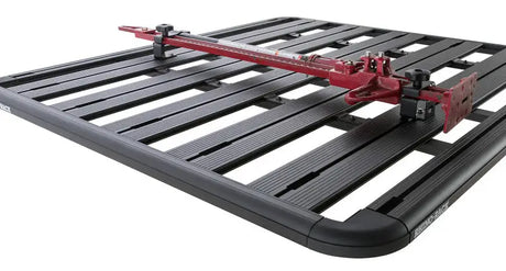 Rhino-Rack Pioneer High Lifting Jack Holder Bracket Set (Top Mount) securely attached to a black Rhino-Rack Pioneer system, holding a red high lifting jack.