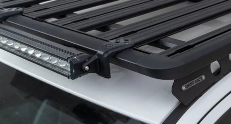 Black roof rack with light bar and Rhino-Rack Pioneer light bar adaptor in package