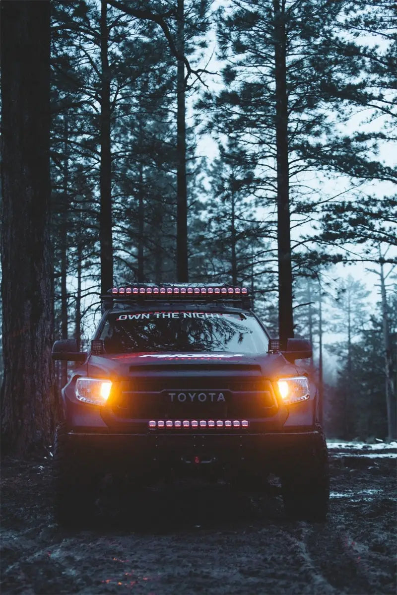 Toyota truck equipped with Rigid Industries 30in Adapt Light Bar in a forest setting.