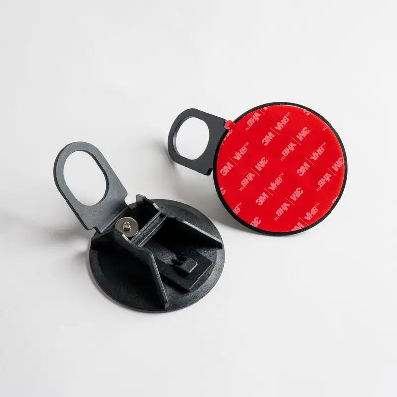 Two black, circular, adhesive-backed phone mounts.