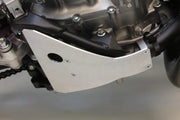 Silver motorcycle skid plate with oil drain access protecting frame rails