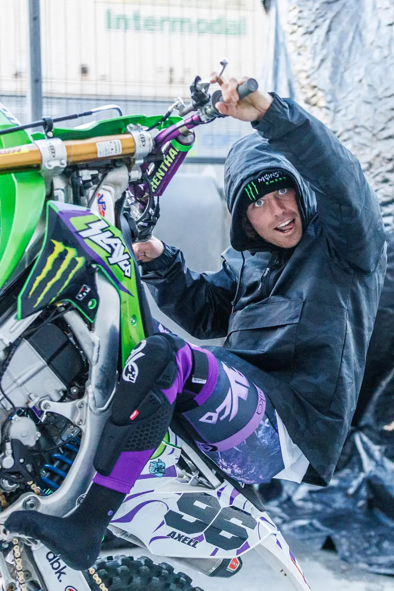Motocross rider showcasing Slayco96 Knee Pad Lg/Xl while performing a bike trick in outdoor setting.
