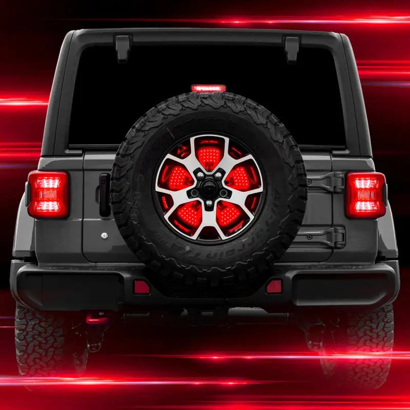 Spare tire brake light hub mount with smoke lens, red and white LED bulbs, featuring running, brake, reverse, and sequential turn functions, attached to the rear of a vehicle.