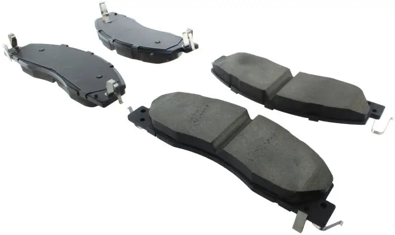 Four dark gray StopTech Sport Brake Pads with silver clips for rear braking system