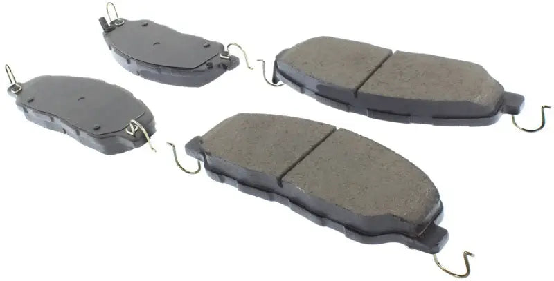 Four grey StopTech Street Select brake pads with metal clips for front brake upgrade