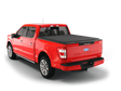 Red Ford F-150 pickup truck with tonneau cover.