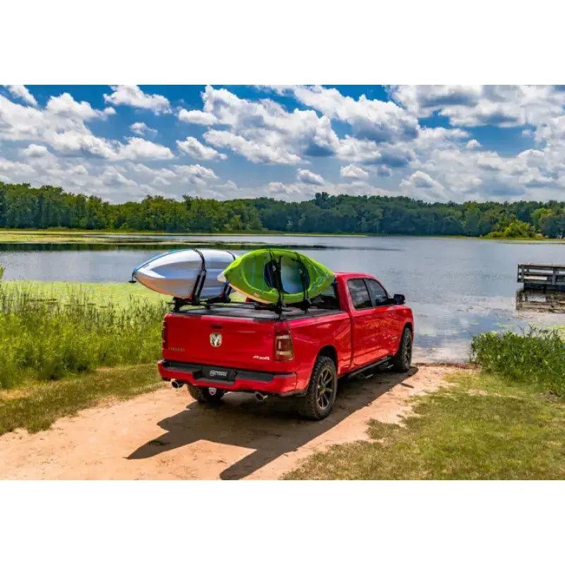 Red pickup truck with kayaks showcasing Tonneau Cover Manual Retractable with Trax Rail System