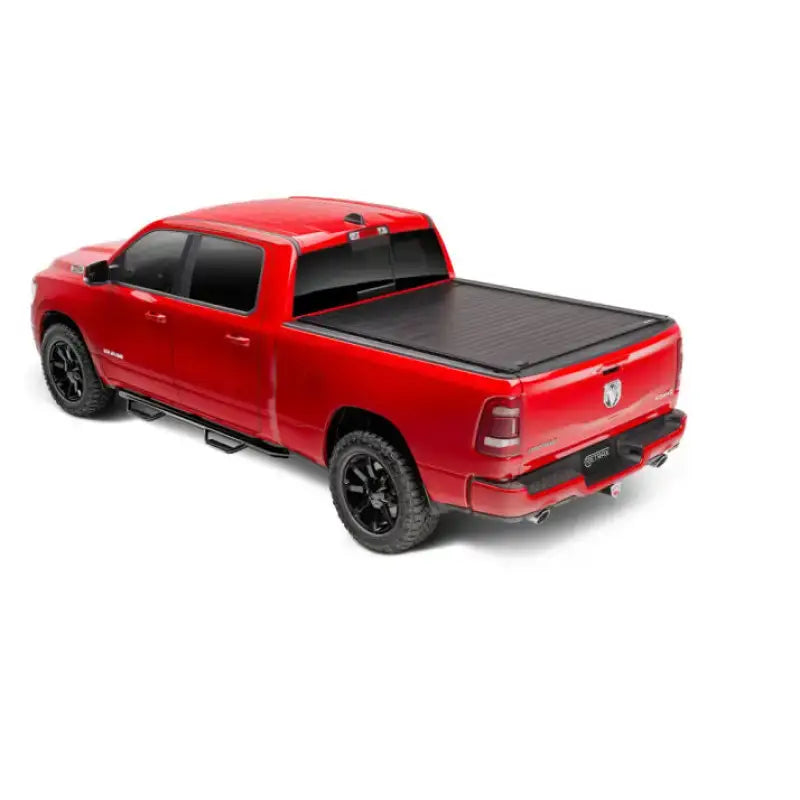 Red pickup truck with black matte manual retractable tonneau cover and trax rail system