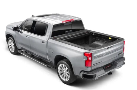 Silver Chevrolet Silverado pickup with a matte black power retractable tonneau cover