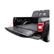 Black pickup truck with open tailgate.