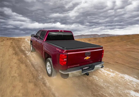 Maroon Chevrolet Silverado with a black bed cover.