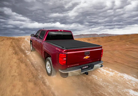 Maroon pickup truck with bed cover.