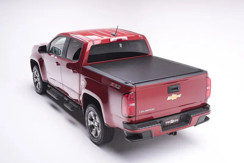 Maroon Chevrolet Colorado with black tonneau cover for truck bed protection