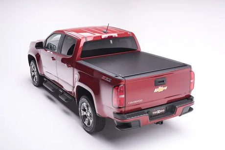 Maroon Chevrolet Colorado with black tonneau cover for truck bed protection