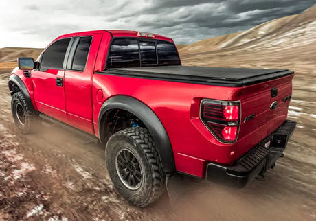 Red Ford Raptor pickup truck with Truxedo 2023 GMC Canyon bed cover on bed cover