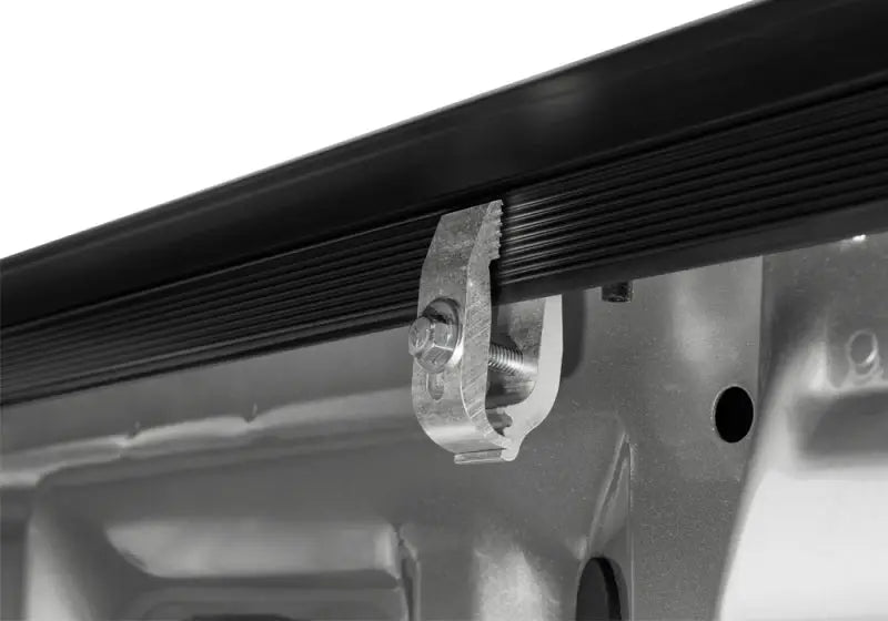 Silver metal clamp on black truck bed rail for Truxedo Sentry tonneau cover
