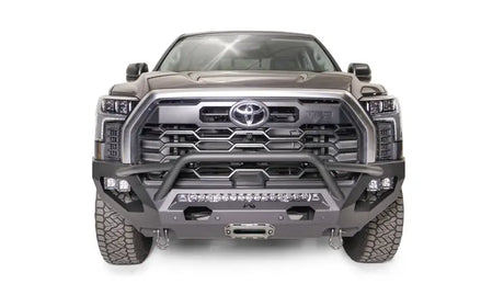 Front view of a gray Toyota truck equipped with a TT22-X5452-1 Fab Fours Matrix Bumper, showcasing rugged design and precision engineering by Fab Fours.