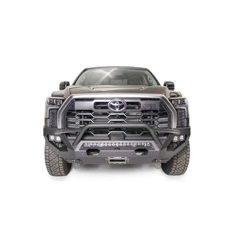 Front view of a gray Toyota truck equipped with a TT22-X5452-1 Fab Fours Matrix Bumper, showcasing rugged design and precision engineering by Fab Fours.