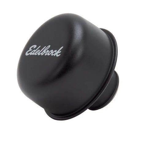 Black Edelbrock carburetor float bowl on valve cover breather for engine performance