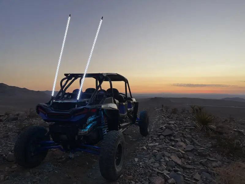 Rugged off-road UTV with 2 illuminated whip flags from Whip It 5Ft Blk Bt Rgb Chase Set
