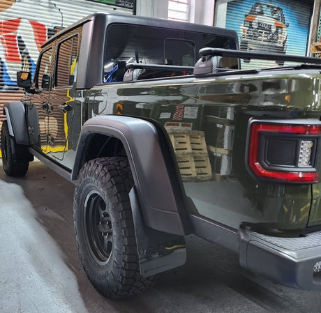 Black Jeep Gladiator displayed indoors showcasing Rally Armor black mud flaps with grey logo, Truck & Automotive, AVADA - Best Sellers